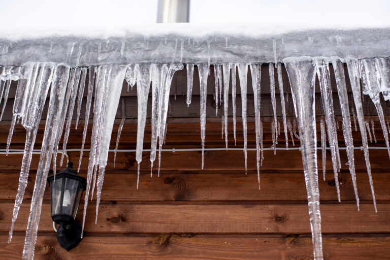 Icicles,Hang,From,The,Roof,Of,A,Wooden,House,In